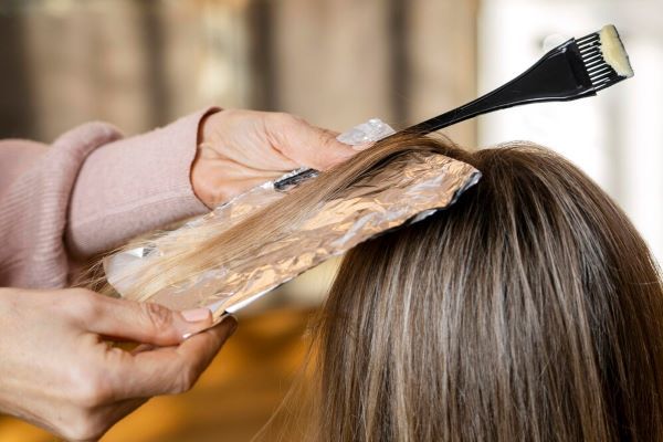 Una donna si tinge i capelli con il parrucchiere. Testare la tintura per capelli