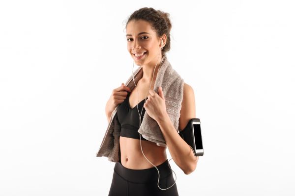Ragazza felice che tiene il suo asciugamano da ginnastica