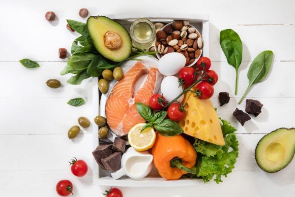 Cibo raggruppato su un tavolo. Le proteine ​​come le uova e il pesce sono una buona fonte di proteine, mentre l’avocado e il formaggio sono buoni compagni.