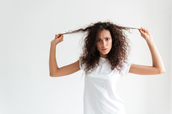 Ragazza che tiene i capelli in posa per la macchina fotografica con la faccia insoddisfatta