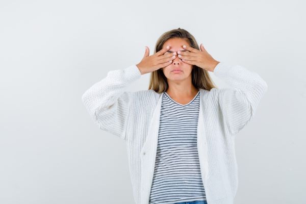Ragazza che si copre gli occhi con le mani