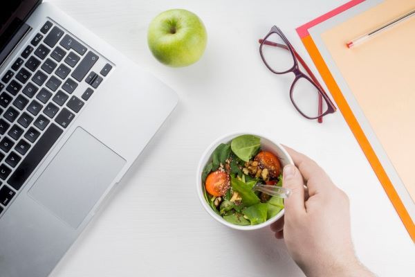 Ragazza che mangia un'insalata al lavoro