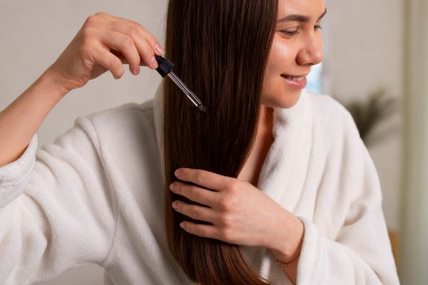 Ragazza che applica il siero sui capelli