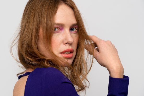 Ragazza di profilo in posa per la fotocamera. Con la cura adeguata, i tuoi capelli fini possono diventare più folti.