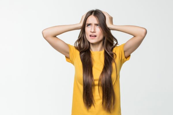 Ragazza angosciata con le mani sulla testa